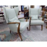 A pair of 1950s/60s stained beech framed wingback armchairs, upholstered in a pale green fabric,