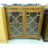 A modern yew bookcase with two astragal glazed doors,