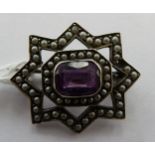 A silver star design brooch,