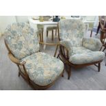 Two similar Ercol stained beech framed chairs with cushioned backs and seats,