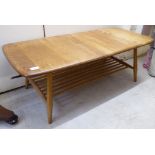 An Ercol elm coffee table, the top raised on splayed, turned, tapered legs,