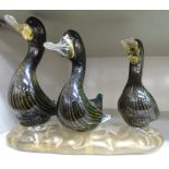 A set of three mid 20thC Murano clear and gilded glass ducks, on an oval plinth 6.