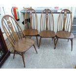 A set of four Ercol beech and elm framed high hoop back dining chairs with carved swan splats,