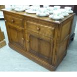 An Ercol elm cabinet with two drawers and two panelled doors,