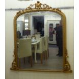 A late Victorian overmantel mirror, set in an ornate gilt frame,