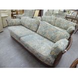 An Ercol beech and elm framed three piece suite comprising two three person settees,