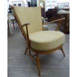 An Ercol light stained beech framed arm chair with a cushioned back and seat,