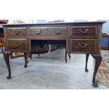 A 1930s mahogany five drawer kneehole desk with a scriber,