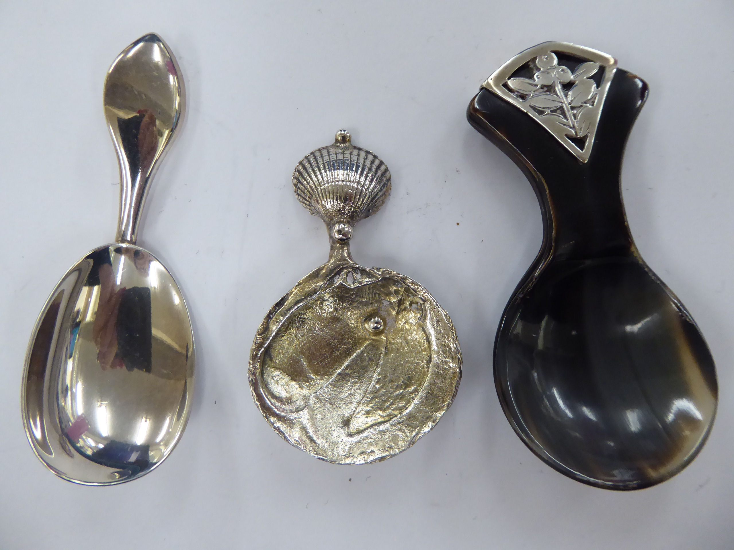 A cast silver caddy spoon, the bowl fashioned as a pearl in an oyster shell,