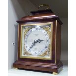 A 1950s Elliott mahogany cased mantel timepiece with a folding crest handle;