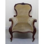 A late Victorian mahogany showwood framed grandfather chair with a carved crest and enclosed arms,