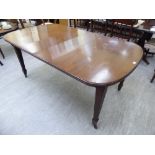 An early 20thC mahogany extending dining table, the oval top raised on square,