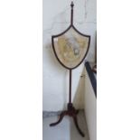 A mid Victorian mahogany polescreen, the shield shaped pictorial tapestry set panel,