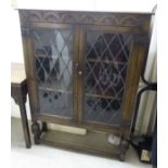 An Old English style stained oak bookcase with a pair of glazed doors,