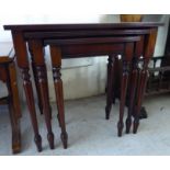 A nesting set of three modern crossbanded mahogany occasional tables,