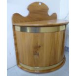 A modern bleached pine demi-lune bin with a hinged lid, enclosing a removable steel liner,