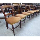 A set of six early 20thC walnut and beech framed bar back dining chairs,