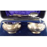 A pair of silver navette shaped salt cellars with blue glass liners,