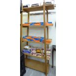 A modern light oak five tier bookcase of pyramid design,