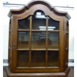 A modern oak hanging display cabinet with a glazed door, enclosing two shelves,