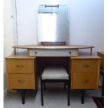 A 1970s light oak finished dressing table, surmounted by a mirror, over five drawers,