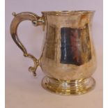 A George III silver small mug of baluster form with a double C-scrolled handle,
