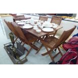 A modern May Fair teak garden table, the top with rounded corners,