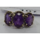 A 9ct gold three stone claw set amethyst and diamond ring 11