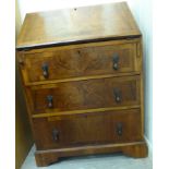 An early 20thC crossbanded walnut bureau, the fall flap over three long drawers,