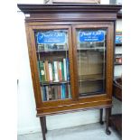 An early/mid 20thC oak display cabinet with a pair of branded glazed doors,