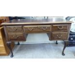 A 1930s mahogany five drawer kneehole desk with a scriber,