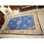 A Chinese washed cotton carpet, decorated with vases and flora,