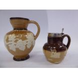 A Doulton Lambeth two tone brown glazed stoneware miniature wine jug of ovoid form with a strap
