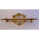 A 15ct gold bar brooch, surmounted by an open circular frame,