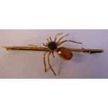 A 9ct gold bar brooch, surmounted by a spider,
