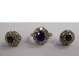 A gold coloured metal claw set sapphire and diamond cluster ring and a pair of matching earrings