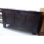 A late 18thC stained oak coffer with straight sides, a tri-panelled front and a hinged lid,