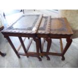 A nesting set of three mid 20thC teak occasional tables with relief carved floral,