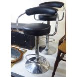 A pair of bar stools, the black faux hide,