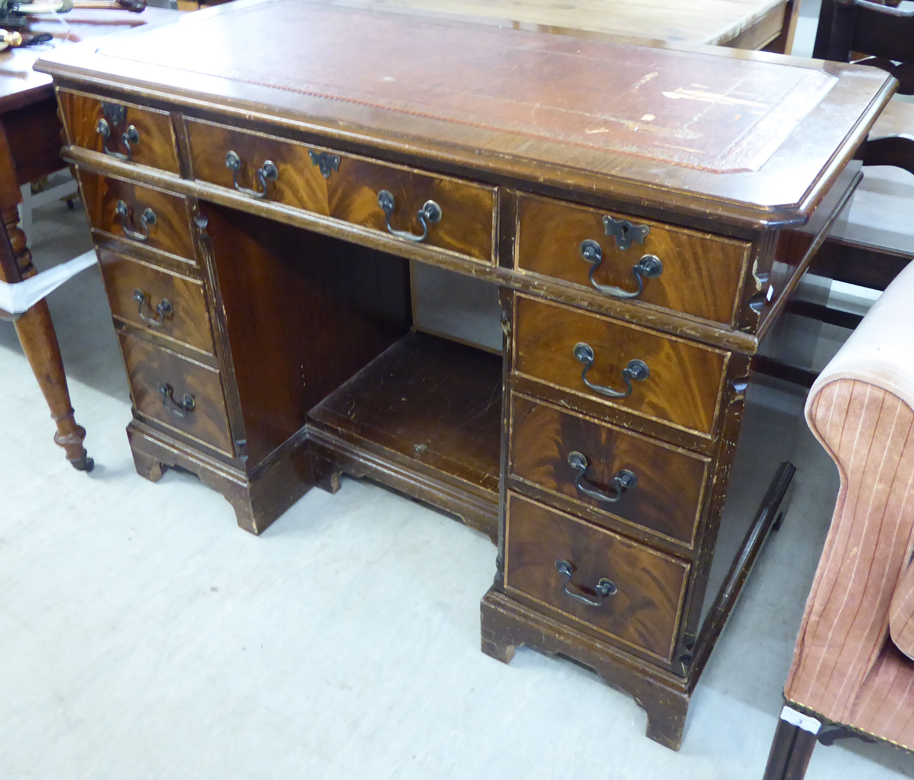 A mid 20thC mahogany nine drawer, twin pedestal desk,