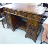 A mid 20thC mahogany nine drawer, twin pedestal desk,