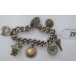 A silver curb link charm bracelet with seven pendants: to include a compass,