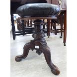 A late Victorian music stool, the rexine upholstered, overstuffed, rotating,