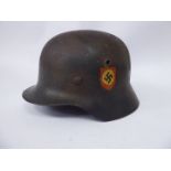 A German military helmet with a hide lining and a chinstrap, impressed NS64,