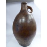 A 17th/18thC brown glazed stoneware bellarmine of ovoid form with a narrow neck,