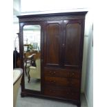 An early 20thC Heal & Son mahogany wardrobe with a dentil and blindfret carved cornice,