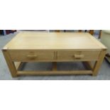 A modern light oak coffee table with two frieze drawers,