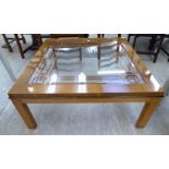 A modern walnut finished coffee table with an inset bevelled glass top,