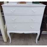 A mid 20thC white painted chest with a low upstand and three graduated long drawers,