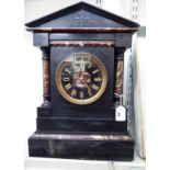 A late Victorian black slate and mottled iron red marble cased mantel clock of architectural form